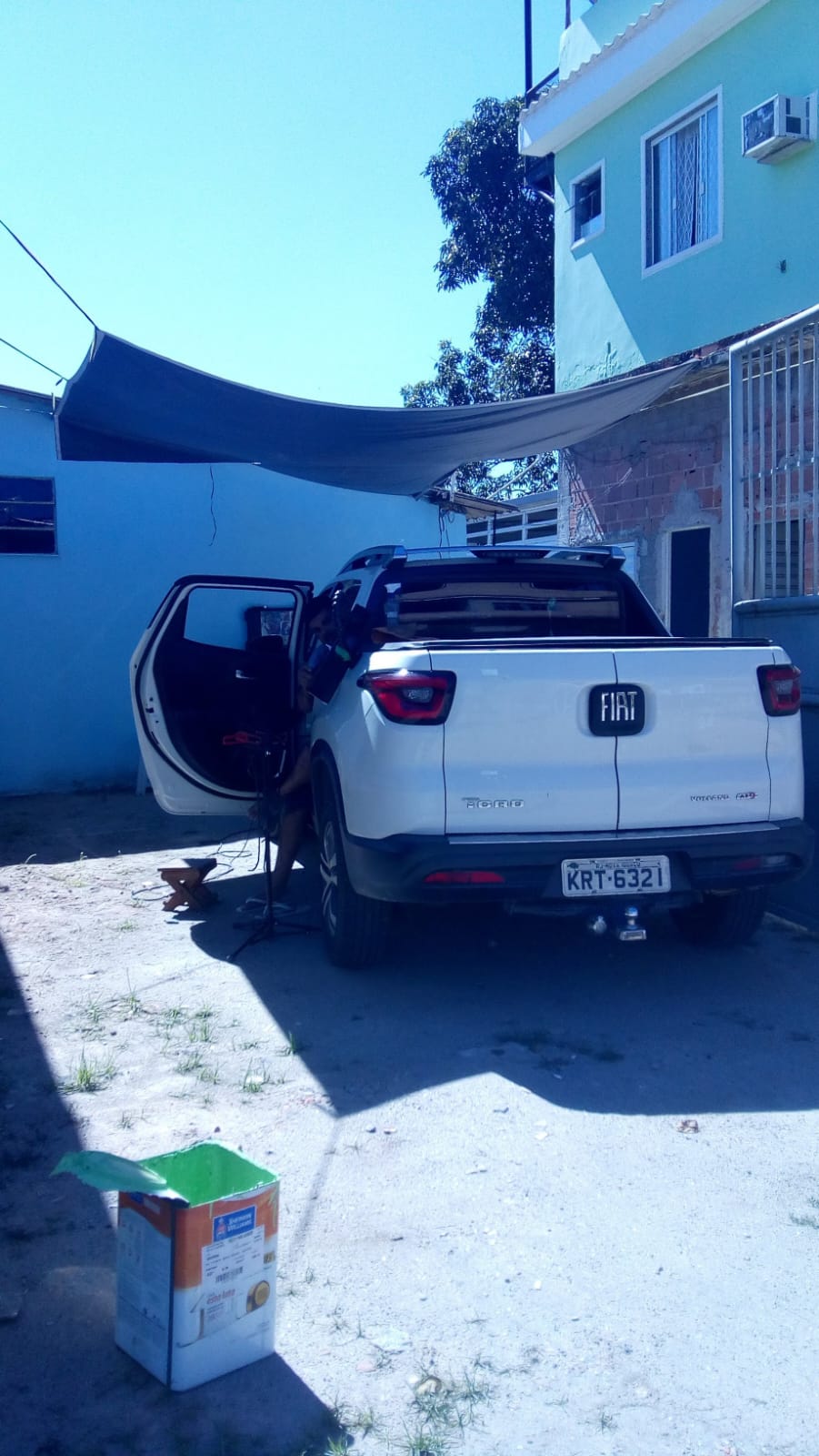 Atendimento a Fiat Toro branca em quintal com toldo improvisado