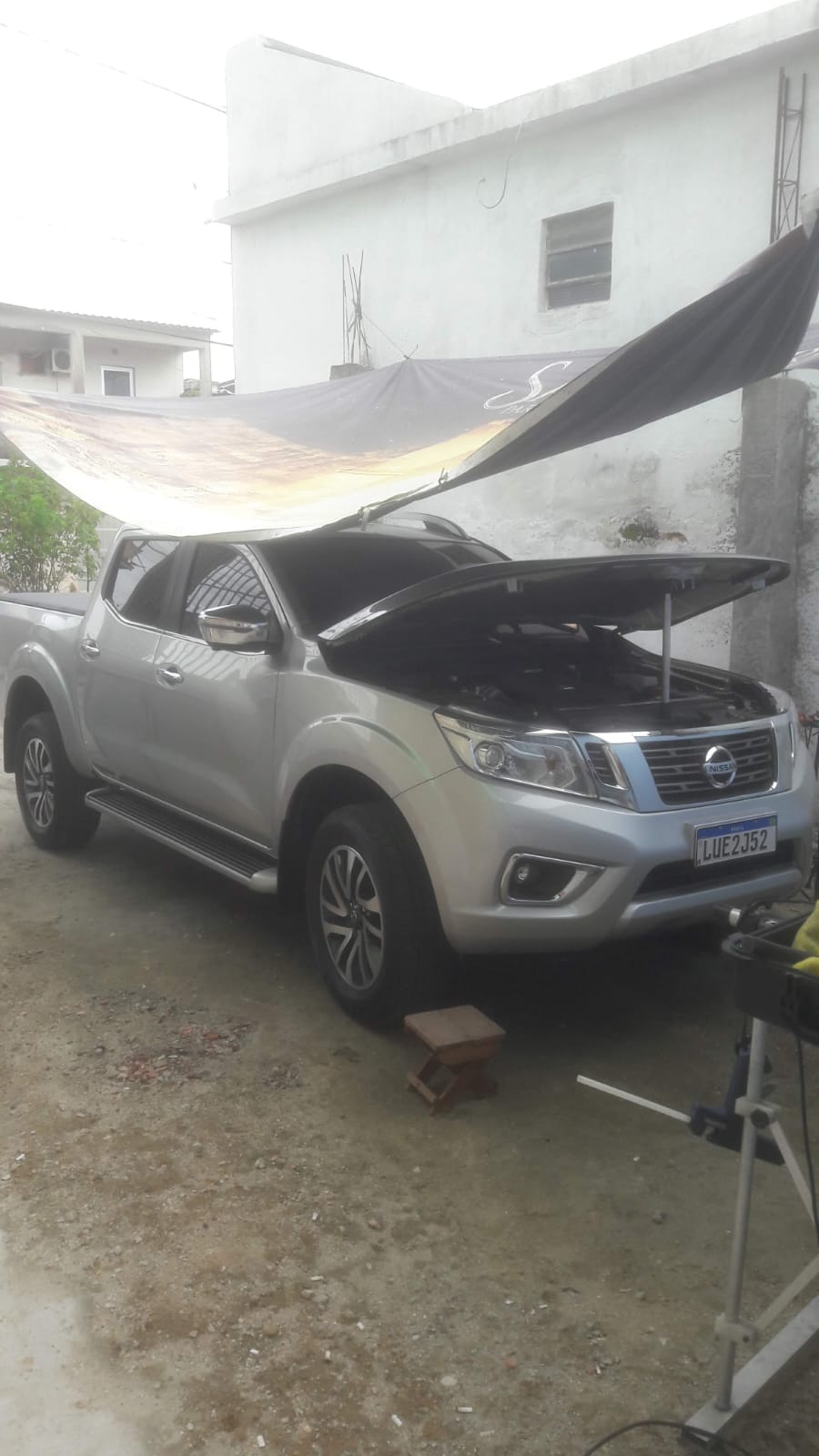 Nissan Frontier prata sob toldo — cliente da primeira fase